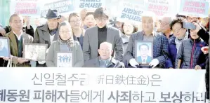  ?? — Reuters photos ?? Choon-shik, a victim of wartime forced labour during the Japanese colonial period, arrives with supporters holding portraits of fellow deceased laborers in Seoul.