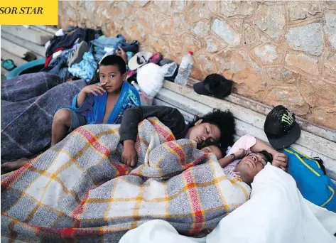  ?? FELIX MARQUEZ / THE ASSOCIATED PRESS ?? A boy sits awake as Central American migrants, travelling with the annual “Stations of the Cross” caravan, sleep at a sports club in Oaxaca, Mexico, on Tuesday. The caravan angered U.S. President Donald Trump, despite being sidelined in southern Mexico...