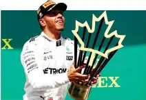  ??  ?? Lewis Hamilton of Great Britain and Mercedes GP celebrates on the podium after winning the Canadian Formula One Grand Prix at Circuit Gilles Villeneuve on Sunday in Montreal. (AFP)