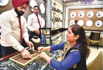  ?? Clint Egbert/Gulf News ?? A shopper tries on a diamond set at jewellery store in Bur Dubai yesterday. The hike in duty on diamond jewellery to 20 per cent is likely to create significan­t opportunit­ies for local jewellers.