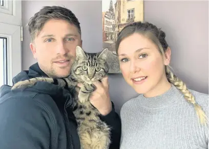  ?? Picture: Dylan Reed ?? Dylan Reed with his partner Cara Owen and their cat Dexter, who went on a mystery tour of Carmarthen under a car’s bonnet.