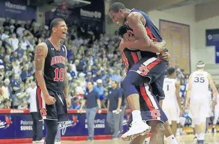  ?? ASSOCIATED PRESS ?? HANG TEN: Auburn players (from left) Samir Doughty, Anfernee McLemore and Horace Spencer celebrate yesterday’s overtime win against Xavier at the Maui Invitation­al.