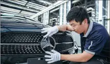  ?? PROVIDED TO CHINA DAILY ?? A Mercedes- Benz employee adjusts a car’s badge at one of the marque’s production bases in China.