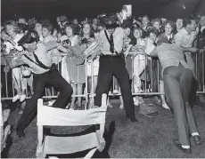  ?? BILL CUNNINGHAM/FILES ?? When the Beatles performed at Empire Stadium on Aug. 22, 1964, The Province’s Bill Cunningham was there to capture the security guards as they tried to hold back the screaming crowd.