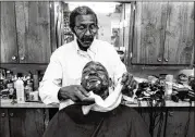  ?? ANTONIO M. JOHNSON ?? A photo of a local man getting a shave at Bank’s Barber Shop in Atlanta appears in the collection “You Next: Reflection­s in Black Barber Shops.”