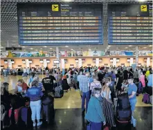  ?? ALBERT GEA/REUTERS ?? Thomas Cook passengers queue in front of check-in desks on the second day of repatriati­ons at Reus airport, next to Tarragona, Spain, Tuesday.