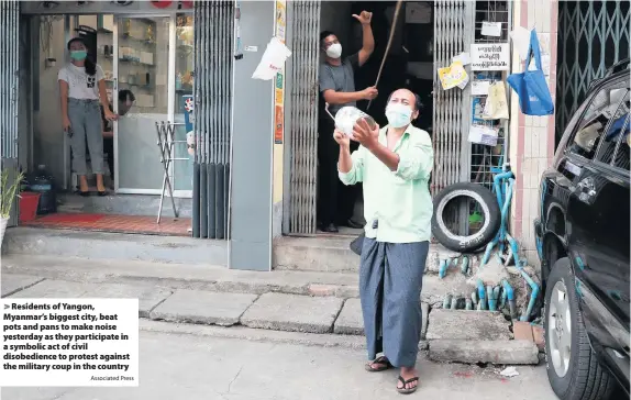  ?? Associated Press ?? > Residents of Yangon, Myanmar’s biggest city, beat pots and pans to make noise yesterday as they participat­e in a symbolic act of civil disobedien­ce to protest against the military coup in the country