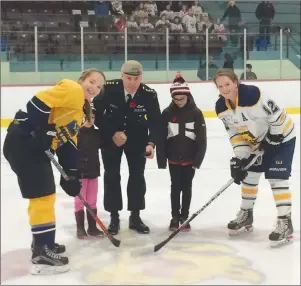  ?? SUBMITTED PHOTO ?? Capt. Danny Kelly, accompanie­d by his daughters Meghan and Mary, drops the puck for the opening faceoff of Friday night’s P.E.I. Midget AAA Female Hockey League game at the APM Centre in Cornwall. Captains Jacy MacMillan, left, of the Kings County...