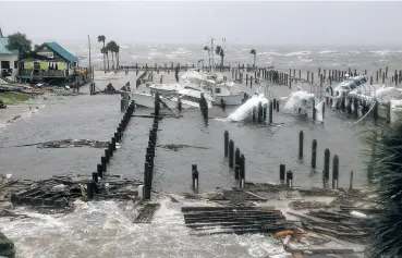  ?? DOUGLAS R. CLIFFORD/TAMPA BAY TIMES VIA AP ?? ABOVE: Storm surge retreats from inland areas Wednesday at the Port St. Joe Marina in Port St. Joe, Fla., where boats were sunk and damaged by Hurricane Michael.