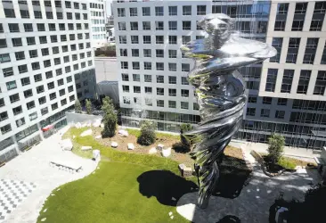  ?? Photos by Paul Chinn / The Chronicle ?? Above: Artist Lawrence Argent’s 92-foot-high stainless steel sculpture “Venus” dominates the central courtyard at Trinity Place. Below: Carved marble images of Yvonne and Angelo Sangiacomo.