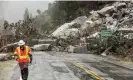  ?? Photograph: Noah Berger/AP ?? Caltrans maintenanc­e supervisor Matt Martin walks by a landslide caused by heavy rains covering Highway 70 in Plumas county, California, in October 2021.