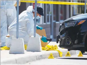  ?? CP PHOTO ?? The police Forensic Identifica­tion unit work around the scene of an explosion at a restaurant in Mississaug­a, Ont. on Friday.