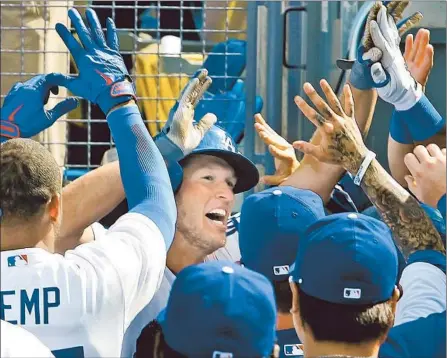  ?? Christina House For The Times ?? CLAYTON KERSHAW is welcomed back to the dugout after leading off the eighth with his first career homer to give Dodgers a 1-0 lead.