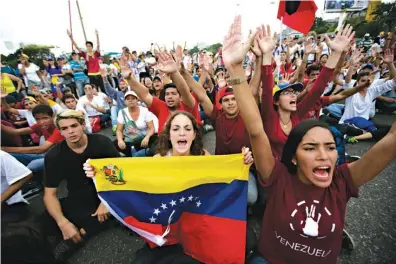 ?? Associated Press ?? ■ University students protest against President Nicolas Maduro on Wednesday in Caracas, Venezuela. Masses of protesters jammed the streets of Venezuela’s capital Wednesday on the heels of a move by congress to open a political trial against Maduro,...