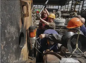  ?? (AP/Andrii Marienko) ?? Workers repair a damaged thermal power plant, one of the country’s largest, recently destroyed by Russian missiles near Kharkiv, Ukraine, on Friday.