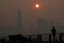  ?? Photograph: Seth Wenig/AP ?? The sun rises over the lower Manhattan skyline through the smoky air on 8 June.