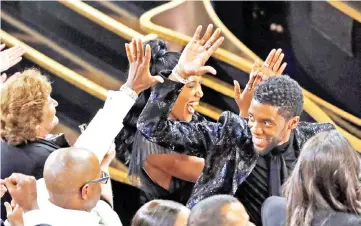  ??  ?? Cast of ‘Black Panther’ celebrate after Ruth E. Carter wins the Best Costume Design Oscar award. — Reuters photo