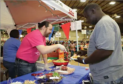  ?? Staff photo by Hunt Mercier ?? ■ Debo Ricks is served a tasty treat Tuesday from U.S. Pizza Co. at the annual Taste of Texarkana. About 40 vendors were on hand to help raise money for the Harvest Regional Food Bank.
