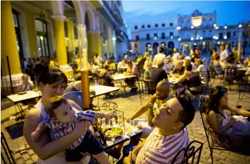  ?? (AP Photo/Enric Marti) ?? A family enjoys a meal and beer at a square in Havana, Cuba, Monday, Dec. 5, 2016. Nine days of mourning for Fidel Castro end and Cuba begins to resume its life, with music in the streets, alcohol sold again and work returning to a normal pace.