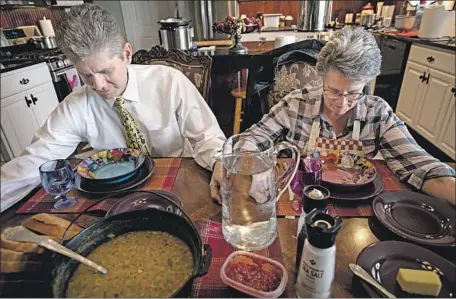  ?? Photograph­s by Francine Orr Los Angeles Times ?? DAVID AND SUE Gillmore pray before lunch Sunday at their home in Shelley, Idaho, a town of 4,409 far removed from coronaviru­s cases.