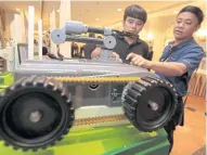  ?? CHANAT KATANYU ?? Vocational students check out a robotic machine displayed at an event held by the Defence Technology Institute.