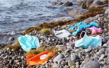  ??  ?? RIGHT
Disposable masks, medical gloves and used personal protective equipment waste washed up on the shore