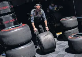  ??  ?? Un miembro de Pirelli retira neumáticos usados de F1.