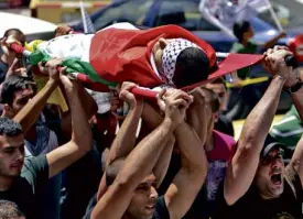  ?? AP ?? MOURNERS carry the body of Ahmed Saoud during his funeral in the West Bank city of Nablus.