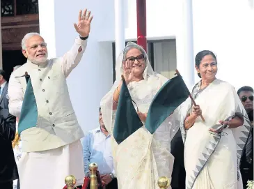  ?? EPA ?? Indian Prime Minister Narendra Modi, Bangladesh’s Prime Minister Sheikh Hasina (centre) and the Chief Minister of the Indian state of West Bengal Mamata Banerjee wave off a bus service between India and Bangladesh in Dhaka yesterday.