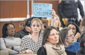  ?? Steve Pfost / Getty images ?? Sara dipper, with the children’s advocacy group “Punished 4 Protecting,” holds a sign while the nassau County Legislatur­e Health Committee holds a hearing in response to the death of thomas Valva on feb. 5.