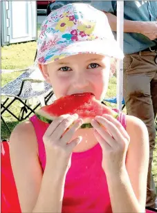  ?? SALLY CARROLL/MCDONALD COUNTY PRESS ?? Brooklea Anderson enjoys a slice of sweet watermelon at the Noel First Friday/Back-to-School event.