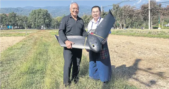  ??  ?? Mr Vivatvong (left) holds a fixed-wing drone from SenseFly.