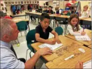  ?? CAROL HARPER — THE MORNING JOURNAL ?? First-grade teacher Dan Bierek asks Carlo Dimacchia and Maria Gigliotti their ideas for letters to soldiers and sailors as part of Project Patriot May 25, at Toni Morrison Elementary School at 1850 W. 40th St. in Lorain.