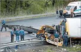  ?? SETH WENIG/AP ?? Emergency workers examine a school bus after it collided with a dump truck Thursday in Mount Olive, N.J. The crash killed a teacher and student and injured 44 others, including the truck driver. The bus, en route to Waterloo Village, had seat belts.