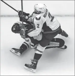  ?? The Associated Press ?? KNOCKED COLD: Pittsburgh’s Sidney Crosby, left, takes a hit from Washington’s Matt Niskanen during the first period of Monday night’s NHL Eastern Conference semifinal game in Pittsburgh. Crosby left the game and did not return. The visiting Capitals...