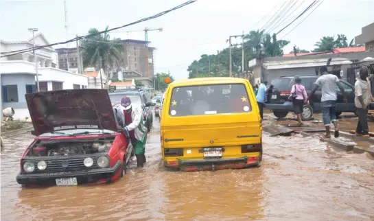  ?? PHOTO: OLADIPUPO ODUNEWU ?? Motorists trapped in a flood along Isaac John Street in Ikeja, Lagos, after a heavy downpour yesterday morning.