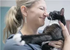  ?? DARRYL DYCK/THE CANADIAN PRESS ?? Shelly Roche holds her eight-month-old rescue cat Cassidy, who has no rear legs, after he received Botox injections in Vancouver.