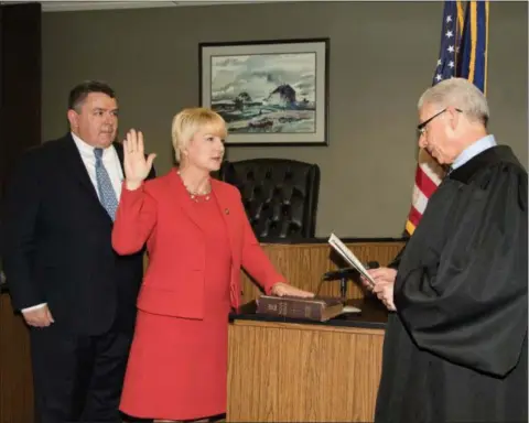  ?? PHOTO PROVIDED ?? Assemblywo­man Mary Beth Walsh, R-Ballston, takes the oath of office for a second term as her husband, Jim, looks on. The oath was administer­ed by Judge Paul Pelagalli, right, in the Saratoga County Family Court room.