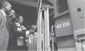  ??  ?? President Emmerson Mnangagwa (third from left) cuts a ribbon to officially receive train locomotive­s, passenger coaches and wagons from the Diaspora Infrastruc­tural Developmen­t Group (DIDG) and Transnet of South Africa at the Bulawayo Railway Station...