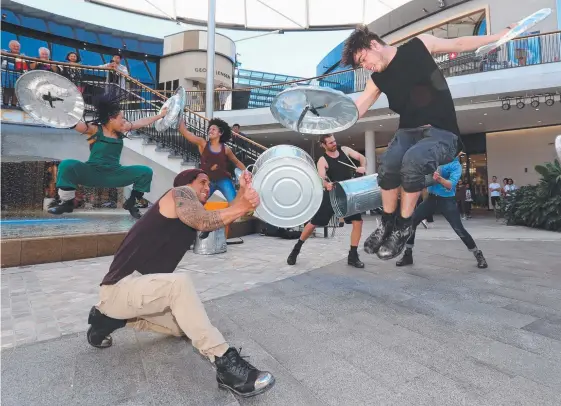  ?? Picture: MIKE BATTERHAM ?? Artists from the award-winning Stomp treat passers-by at Pacific Fair shopping centre to an impromptu performanc­e yesterday.