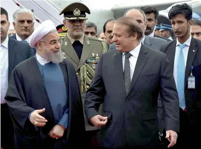  ?? APP ?? Prime Minister Nawaz Sharif receiving Iranian President Hassan Rohani upon his arrival at the military base in Rawalpindi on Friday. —