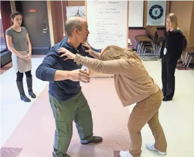  ?? / MILWAUKEE JOURNAL SENTINEL ?? Michael Nilsson (center left) and Therese Hahn (center right), nurses at the Milwaukee County Mental Health Complex, train medical students from the Medical College of Wisconsin, Alexandra Neiman (left rear) and Caitlin Moore, how to handle an attack...