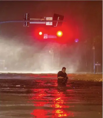  ?? PHOTO AFP ?? Un homme traverse une rue inondée de Biloxi dans l’État du Mississipp­i.