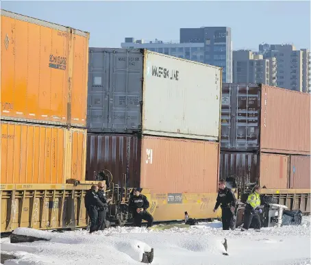  ?? DEREK RUTTAN ?? Police stand over the body of a sidewalk snowplow operator that was struck by a CN train in London on Tuesday.