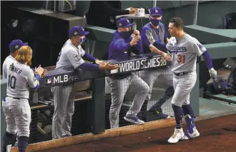  ?? Sean M. Haffey / Getty Images ?? Joc Pederson is greeted by bench coach Bob Geren and other Dodgers after his solo home run against the Rays in the second inning of Game 5 of the World Series on Sunday.