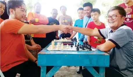  ??  ?? LUGAIT CHESS TOURNEY. Ceremonial moves between SK chairman Ernest Augusto III and Brgy. chairman Disederio Gabe. (Supplied Photo)