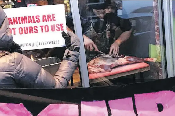  ?? — MARNI JILL UGAR ?? Chef Michael Hunter cuts a leg of venison at his restaurant as animal rights activists protested outside.