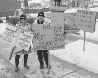  ?? DAVID MAHER/THE TELEGRAM ?? Protesters Heather and Nina display their signs on Saturday, after eight other protesters had left the War Memorial.