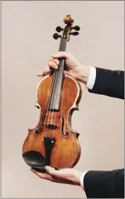  ?? ANDREW WHITE — THE NEW YORK TIMES ?? Jason Price, director of Tarisio auction company, holds the - da Vinci” Stradivari­us violin in Berlin, Germany, on April 30. Crafted in 1714 and played in “The Wizard of Oz” and other classic films, Toscha Seidel's Stradivari­us could sell for almost $20million at an online auction.