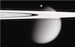  ?? —AP ?? This image made by the Cassini spacecraft and provided by NASA on March 12, 2006, shows two of Saturn’s moons, the small Epimetheus and smog-enshrouded Titan, with Saturn’s A and F rings stretching across the frame.
